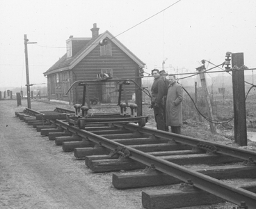 886049 Afbeelding van een proefopstelling van tractieopzichter B.J. Dikker met een lorrie op een stuk spoor met ...